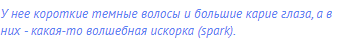 У нее короткие темные волосы и большие карие глаза, а в