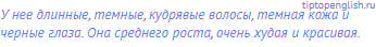 У нее длинные, темные, кудрявые волосы, темная кожа и